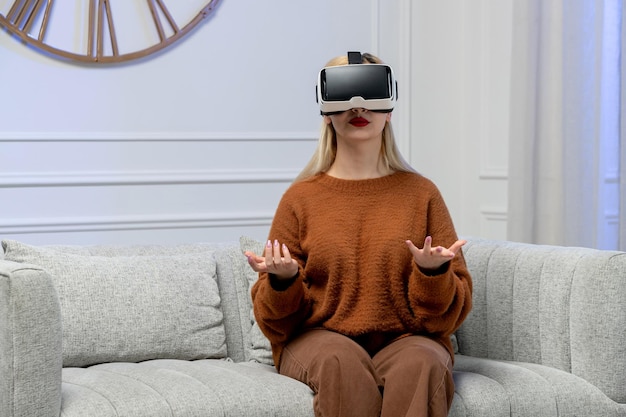 Amor virtual linda jovencita rubia en suéter acogedor con gafas virtuales d agitando las manos