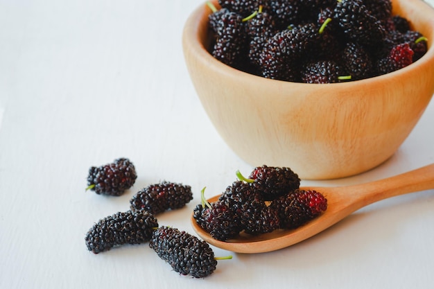 Amora preta em uma colher de pau É uma fruta da família das bagas que é benéfica para a saúde