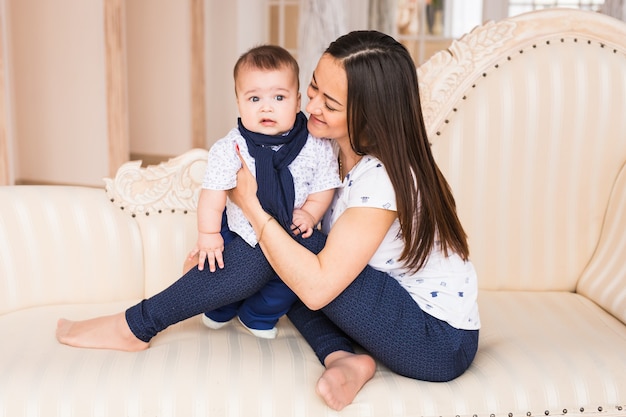 Amorosa joven madre india sosteniendo a su hijo