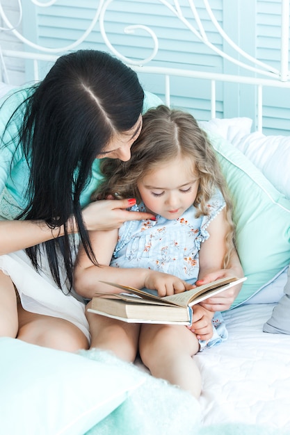 Amorosa madre leyendo un cuento de buenas noches a su hijo