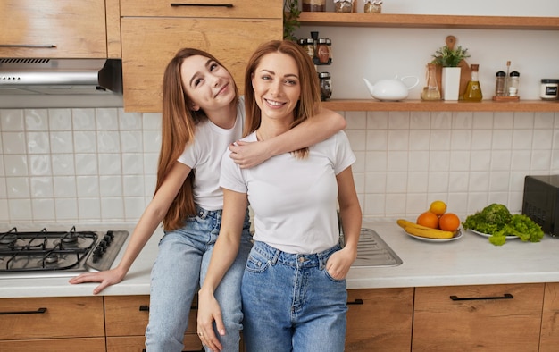 Amorosa mãe e filha abraçando na cozinha