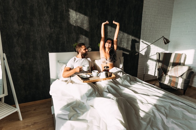 Amorosa pareja desayunando en la cama