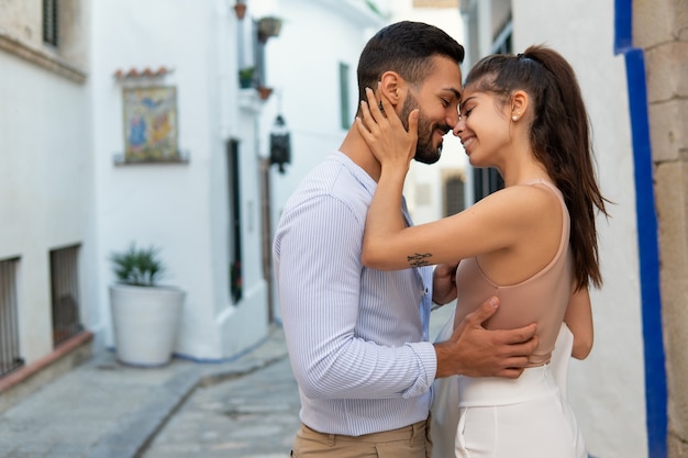 Amorosa pareja étnica abrazándose en la ciudad