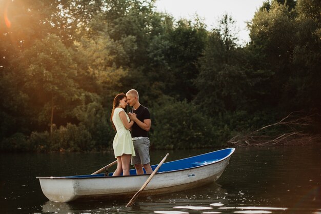 Amorosa pareja joven disfrutando de un barco en el lago