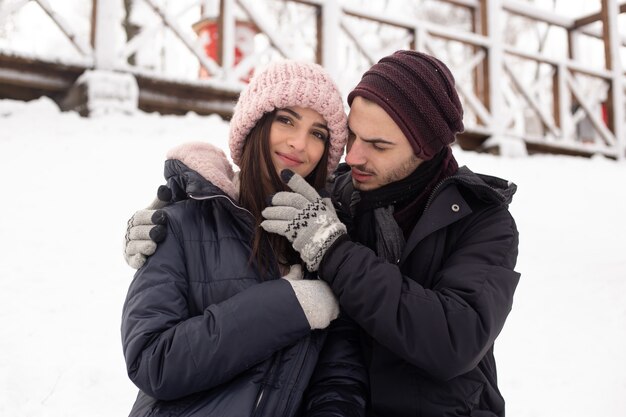 Amorosa pareja joven juntos en el parque en invierno