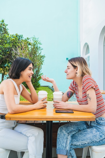 Foto amorosa pareja de lesbianas teniendo una cita en la cafetería