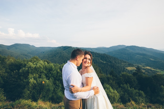 Amorosa pareja de novios en las montañas