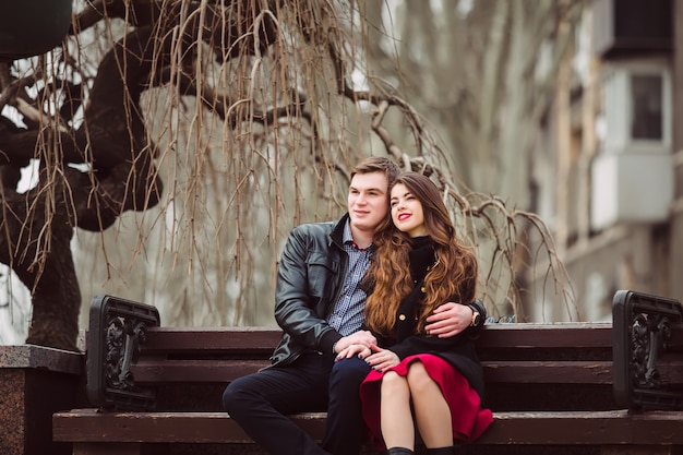 Amorosa pareja sentada en un banco