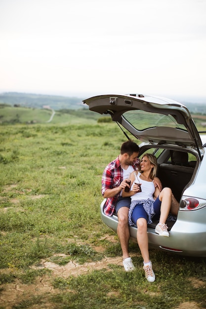 Amorosa pareja sentada en el tranvía del coche durante el viaje en la naturaleza