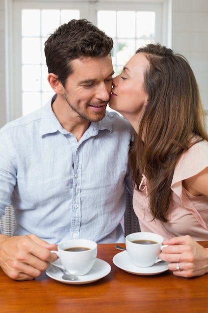 Amorosa pareja con tazas de café en casa