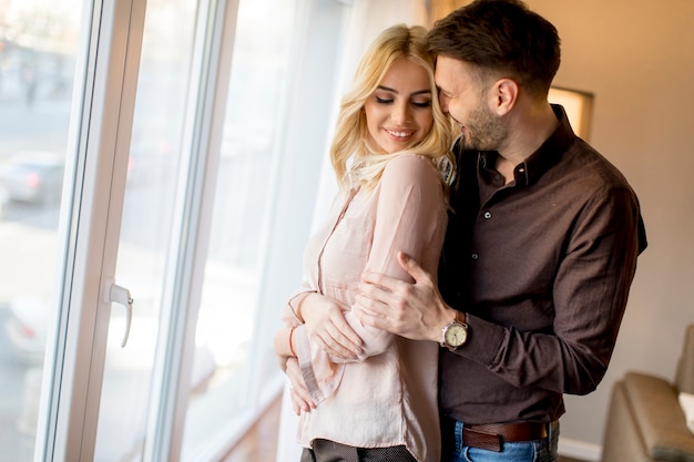 Amorosa pareja por ventana en la habitación