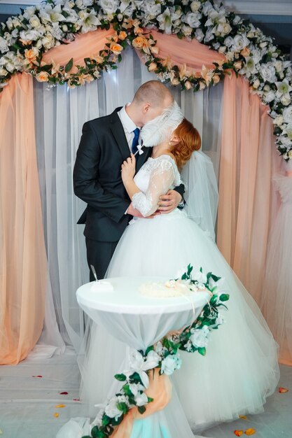 Amoroso abrazo romántico par casado con la celebración de gran pluma blanca. Boda y concepto del día de San Valentín