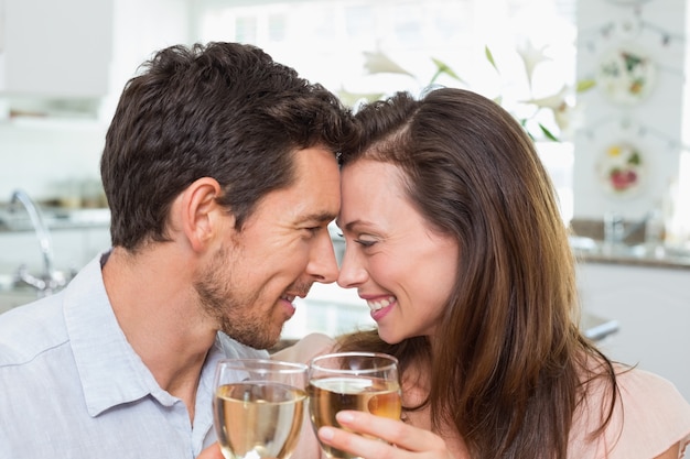 Foto amoroso casal com copos de vinho em casa