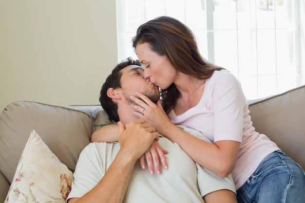 Amoroso casal relaxado se beijando na sala de estar