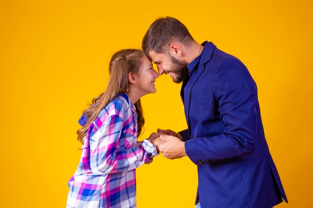 Amoroso padre e hija sobre fondo amarillo Día del padre