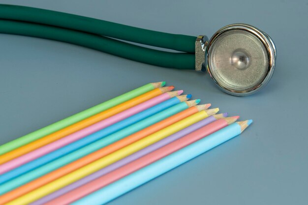 Amostra de lápis de cor e um estetoscópio representando o médico pediatra