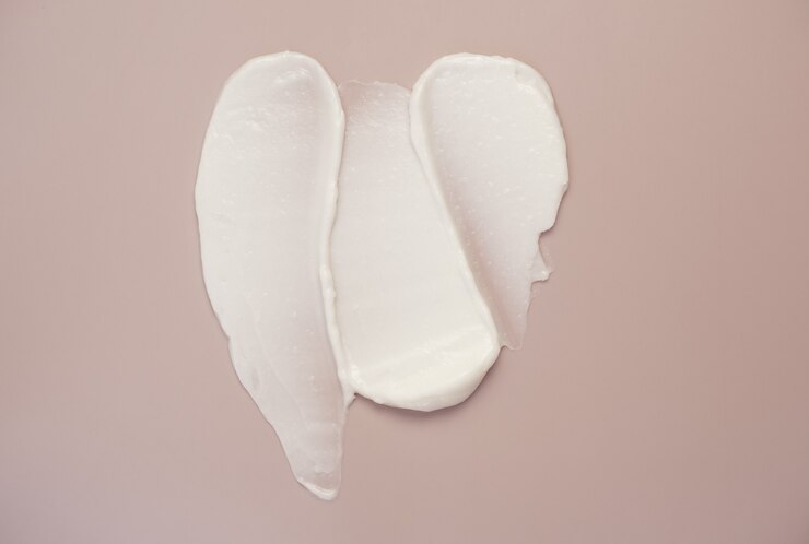Amostra de mancha de marca-texto com loção creme de beleza branca mancha no fundo rosa