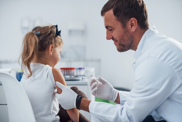 Amostra de sangue. A menina está na clínica com o médico.