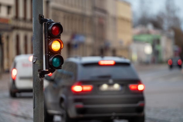 Ampel an der Straßenkreuzung mit schöner Bokeh-Stadt mit Autos im Hintergrund