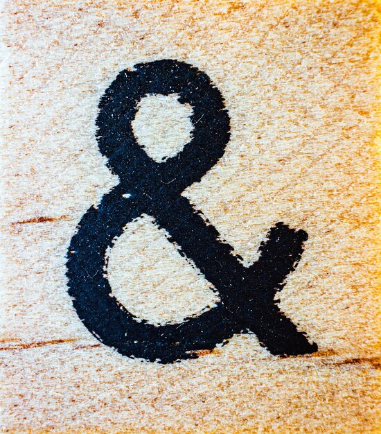 Ampersand y símbolo grabado con láser en madera de balsa macro cerrar detalle de textura