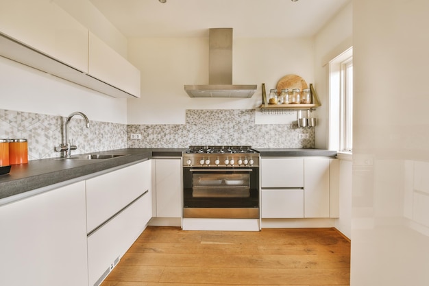 Amplia cocina con muebles blancos y mosaicos en la pared de una casa moderna