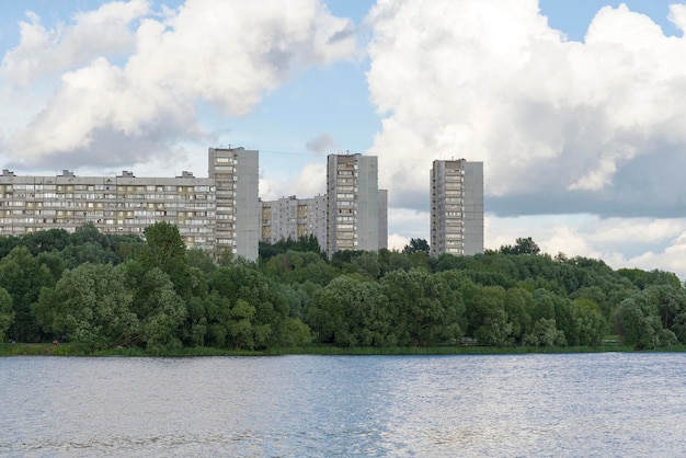 Amplia orilla del río con bosques y casas de varios pisos.