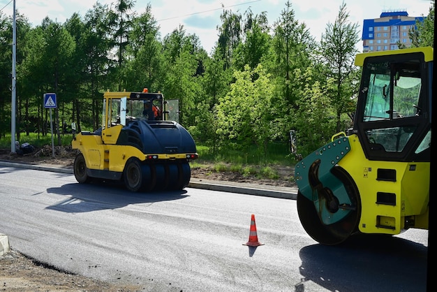 Foto amplia vista de las apisonadoras trabajando en el nuevo sitio de construcción de carreteras