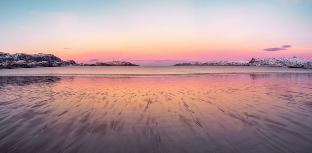 Amplia vista panorámica del atardecer de invierno con un increíble color magenta sobre el fiordo. Teriberka, Rusia.