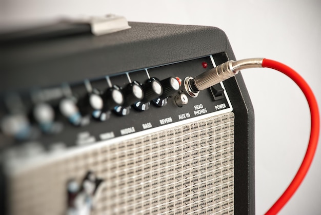 Amplificador de guitarra negro con cable rojo