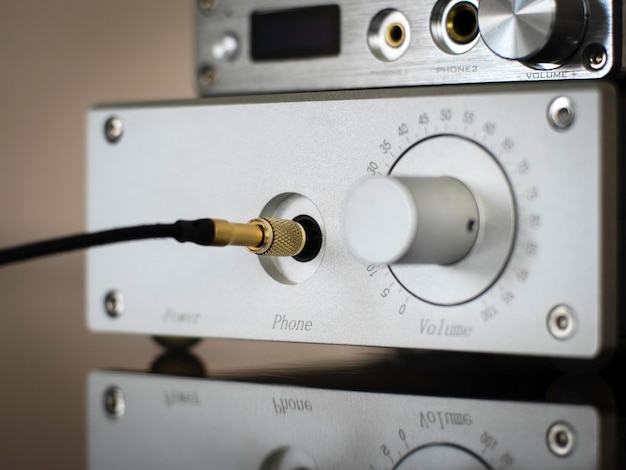 Amplificador prateado com cabo de fone de ouvido jack dourado conectado