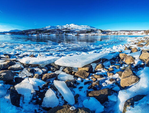 Amplio ángulo de visión del hermoso lago invernal con hielo en la costa de las islas Lofoten en el norte de Noruega