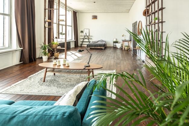 Amplio apartamento tipo estudio decorado con madera y blanco. Diseño minimalista con enormes ventanales a la luz del sol. área de cocina y sala de estar