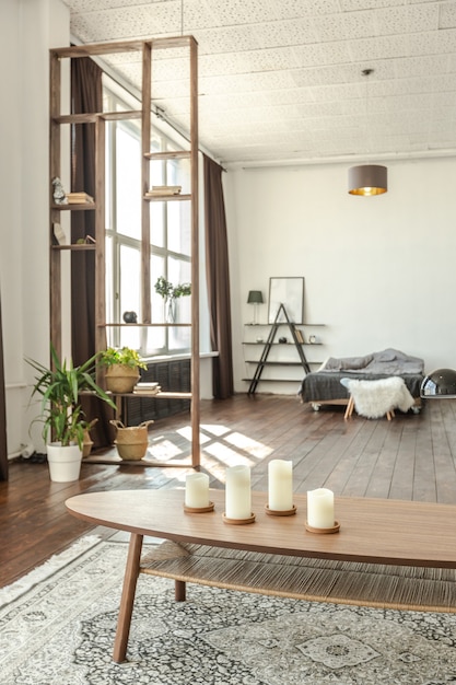 Amplio apartamento tipo estudio decorado con madera y blanco. Diseño minimalista con enormes ventanales a la luz del sol. área de cocina y sala de estar