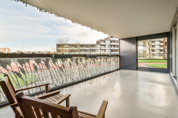 Un amplio balcón con una valla de cristal y un patrón con vistas a la ciudad