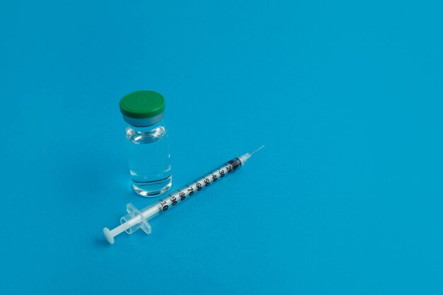 Ampola de seringa com medicamento em fundo azul