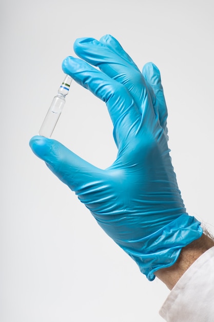 Ampolla de vacuna en mano en un guante médico