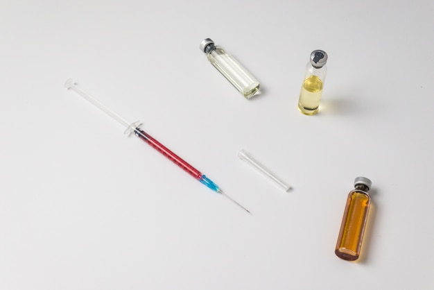 Foto ampollas médicas, infusión y jeringa con inyección.