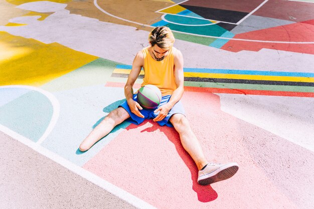 Amputierter kleiner Junge, der Basketball im Park spielt und Sport macht. Konzept über Behinderungen und Persistenz