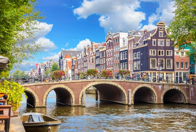 Amsterdam Innenstadt Fluss Amstel alte Häuser und eine Brücke Schöne Aussicht auf die berühmte Stadt Amsterdam Reisen Sie nach Europa Amsterdam Holland Niederlande Europa