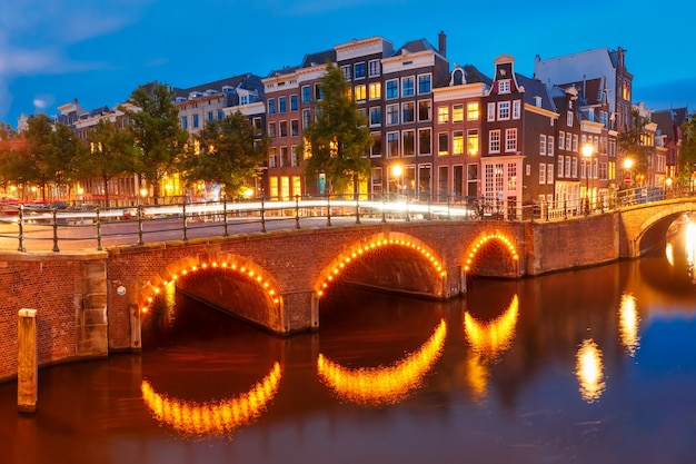 Amsterdam-Kanal Reguliersgracht, Brücke und typische Häuser, Boote und Fahrräder während der blauen Abendstunde, Holland, Niederlande.