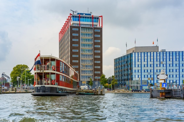 Amsterdam-Kanalboot und modernes Gebäude Holland