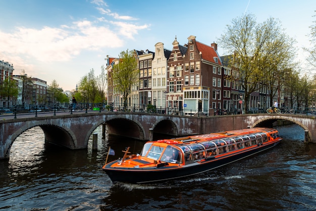 Amsterdam-Kanalkreuzschiff mit niederländischem traditionellem Haus in Amsterdam, die Niederlande.