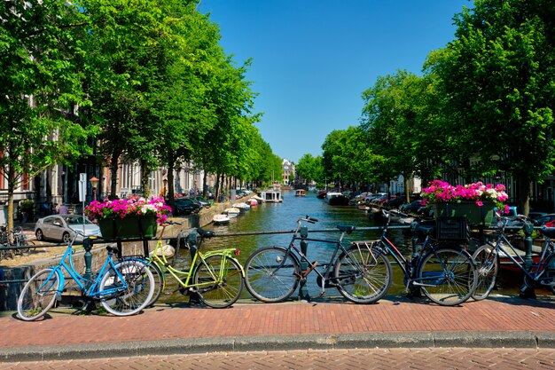 Amsterdamer Kanal mit Booten und Fahrrädern auf einer Brücke