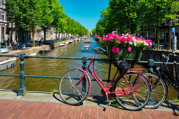 Amsterdamer Kanal mit Booten und Fahrrädern auf einer Brücke