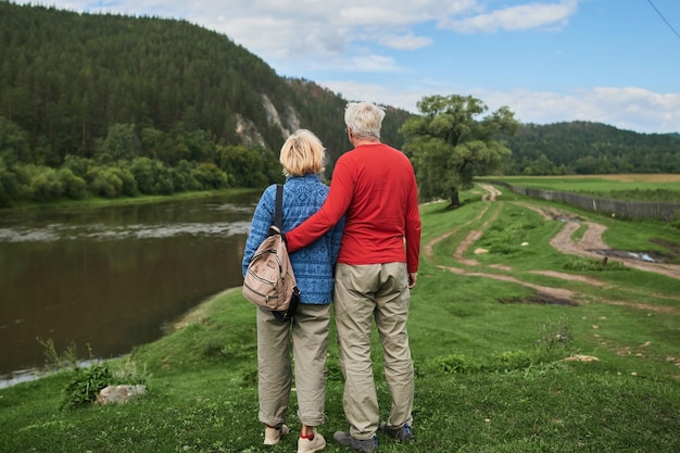 Amüsantes älteres Ehepaar, das sich in der Nähe des Flusses ausruht