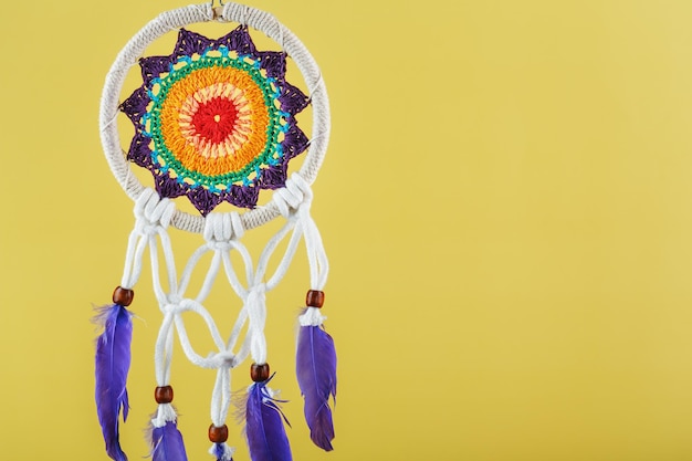 Foto amuleto dreamcatcher em um fundo amarelo com proteção de espaço livre