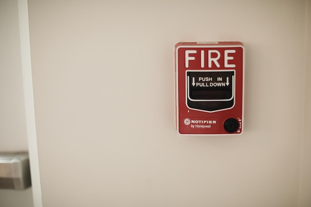 An der Wand befindet sich ein Feuermelder mit einem Knopf, auf dem „Feuer“ steht.