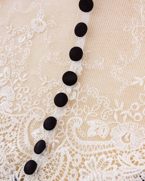Foto an einem spitzenkleid befindet sich eine halskette aus schwarzen perlen.