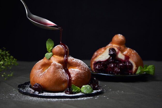 Foto ana bollo con cereza verter mermelada de cerezas