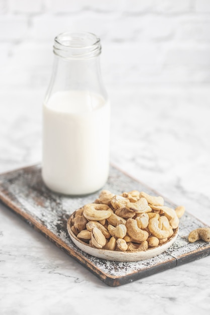 Anacardos crudos en mesa y botella de leche